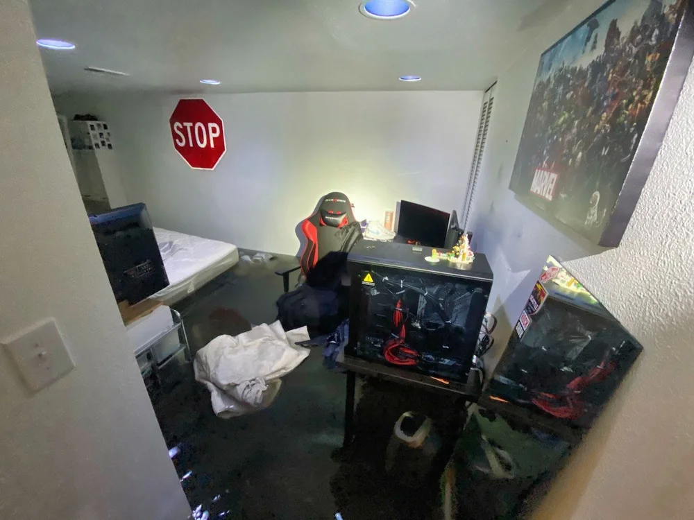 Flooded bedroom with standing water and damaged furniture after water damage