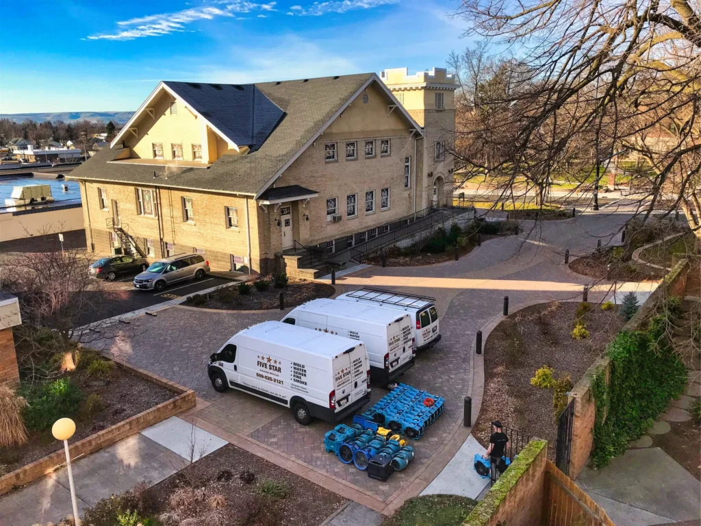 Five Star Disaster Services trucks and restoration equipment on site